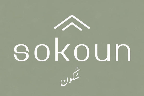 White Sokoun brand logo with an upward arrow icon and the word 'sokoun' on a muted sage green background, with a smaller white script mark below.